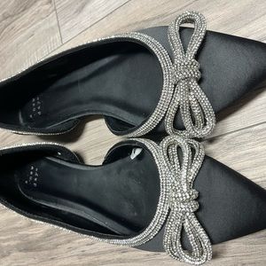 Black dressy flats with silver bow.